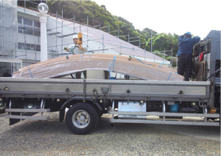 今回は大きな建物で、なおかつ高さがあり、しかも屋根材自体が大きかったので、クレーンを使って荷揚げをしました。半円部分の屋根材はトラックの荷台をほぼ埋め尽くす大きさです。