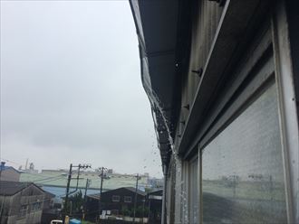 工場雨樋から雨水がは溢れている