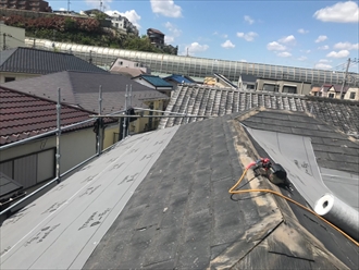 屋根カバー工事のために防水紙を敷設