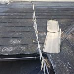 飛散した棟板金が勾配の緩い屋根に引っかかっている