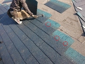 屋根本体を確実に釘で固定している作業風景