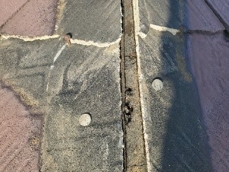 棟板金が飛散してスレートの下に敷かれている防水紙が露出