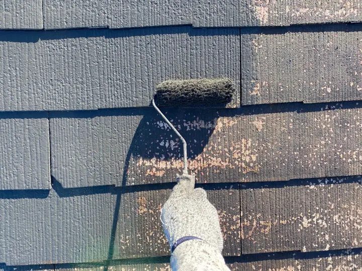 屋根に塗装を施す様子