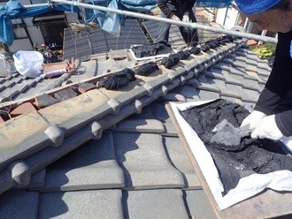 漆喰を塗布して隅棟に熨斗瓦を3段に積み重ねる作業