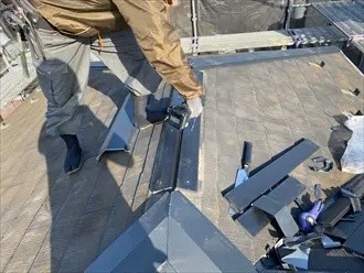 新しいガルバリウム鋼板製の棟板金をビスでしっかり固定