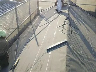 ルーフィングを敷設する作業風景