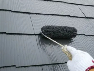 ローラーを使用したグレーの屋根の塗装